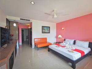 a bedroom with a large bed and a red wall at Aumpai Luxury in Lamai
