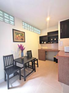 a kitchen with two chairs and a table with flowers on it at Aumpai Luxury in Lamai