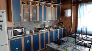 マンジェロクにあるCottage Manzherokのキッチン(青いキャビネット、白い冷蔵庫付)