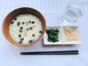 a bowl of rice with broccoli and a plate with a glass of water at Hotel Sharoum Inn 2 in Hakodate