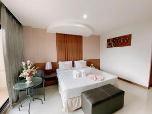 um quarto de hotel com uma cama e uma mesa em The Centris Hotel Phatthalung em Phatthalung