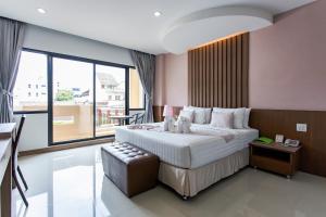 um quarto com uma cama grande e uma janela grande em The Centris Hotel Phatthalung em Phatthalung
