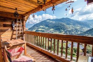 a balcony of a cabin with a view of mountains at Beautiful, atypical loft in the Aravis in Les Clefs