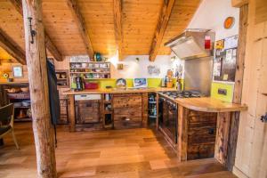een grote keuken met houten vloeren en een houten plafond bij Beautiful, atypical loft in the Aravis in Les Clefs