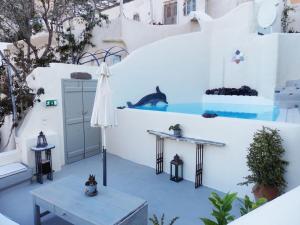 a white house with a swimming pool and a table at w Villa Tian - Emporeio - 3 Bedroom Villa With Private Pool and Jacuzzi in Emporio Santorini