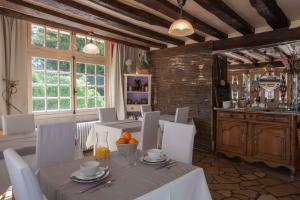 a dining room with white tables and white chairs at Les Pierres de Chevreuse in Chevreuse