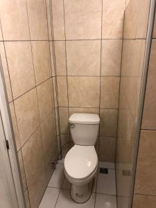 a bathroom with a toilet in a tiled room at Mt Hamiguitan Escape Resort in La Union