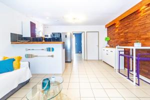 a kitchen and living room with a glass table at KotéZen - à 2 pas de la plage de Trois Bassins in La Saline les Bains