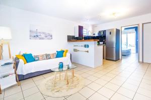 a living room with a couch and a table at KotéZen - à 2 pas de la plage de Trois Bassins in La Saline les Bains