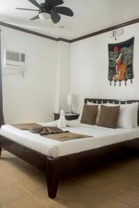 a bedroom with a large bed with a ceiling fan at Isla Gecko Resort in Boracay