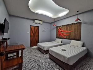 Pokój z 2 łóżkami, stołem i lampką w obiekcie Happy Field Resort w mieście Cha Am