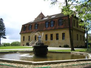 a house with a fountain in front of a building at Zamek Dobra in Oleśnica