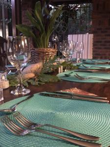 - une table avec des serviettes et fourchettes vertes et des verres à vin dans l'établissement Kambaku @ Sea, à Sedgefield