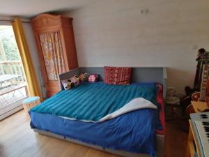 a bedroom with a bed with a blue comforter at Tipergwendiou in Plougonvelin