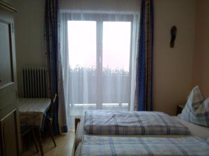 sypialnia z 2 łóżkami i dużym oknem w obiekcie Appartement Hinterleiten w mieście Wagrain
