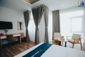 a hotel room with a bed and a desk and a television at Dong Hai Hotel _ Rach Gia in Rạch Giá