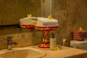 a bathroom with a stack of towels on a sink at D'Junas Villas by GenuineHost in Ubud