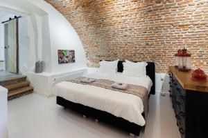 een slaapkamer met een bakstenen muur en een bed bij De Verrassing aan de Werf in Utrecht