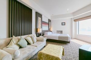 a living room with a couch and a bed at Hotel Seagull Tenpozan Osaka in Osaka