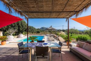 eine Terrasse mit einem Tisch und Stühlen sowie einem Pool in der Unterkunft Son Frare in Artá