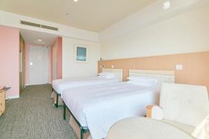 a hotel room with two beds and two chairs at Hotel Seagull Tenpozan Osaka in Osaka