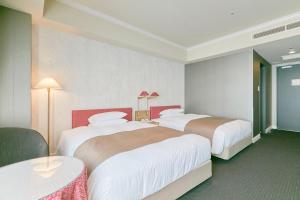a hotel room with two beds and a table at Hotel Seagull Tenpozan Osaka in Osaka