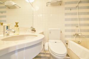 a white bathroom with a toilet and a sink at Hotel Seagull Tenpozan Osaka in Osaka