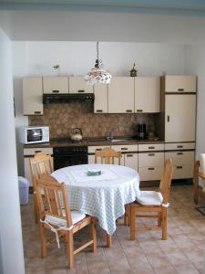 uma cozinha com uma mesa e cadeiras numa cozinha em Ferienwohnungen Frosch em Bischofsgrün