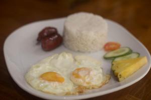 a plate of food with eggs and vegetables on a table at Isla Gecko Resort in Boracay