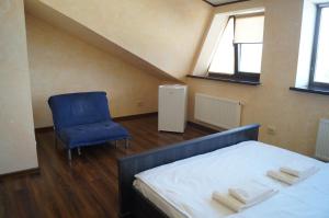 una camera con letto e sedia blu di Rosinka a Ukrayinka