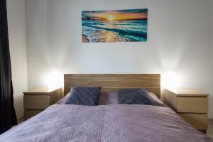 una camera con un letto con due comodini e un dipinto di Wyspa Uznam - Wyspa Uznam a Świnoujście