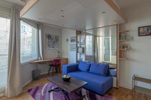 a living room with a blue couch and a table at StayParis in Issy-les-Moulineaux