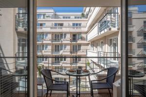 einen Balkon mit einem Tisch und Stühlen sowie Blick auf ein Gebäude in der Unterkunft StayParis in Issy-les-Moulineaux