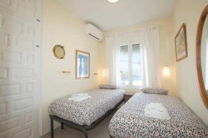 two beds sitting in a room with a window at Seaview and sun all day long in Los Pinos, Almuñecar, Andalusia in Almuñécar