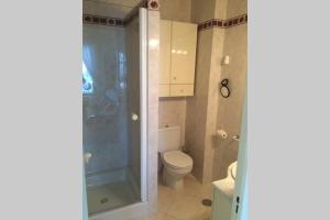 a bathroom with a toilet and a glass shower at Seaview and sun all day long in Los Pinos, Almuñecar, Andalusia in Almuñécar +12 photos