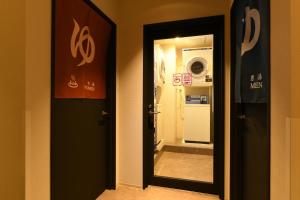 Hotel Wisteria NARA في نارا: باب يؤدي الى حمام مع غرفة غسيل