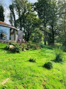 a field of green grass with a house and trees at The Roundhouse in Newton Stewart