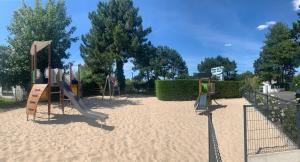 a park with a playground with a slide at Camping Pomme de Pin in Stella-Plage