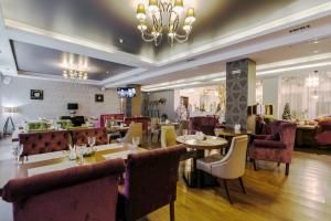 a restaurant with tables and chairs and a chandelier at Vozdvizhenskoe Park Hotel in Serpukhov
