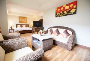 uma sala de estar com cadeiras de vime e um sofá em Luckswan Resort Chiang Rai - SHA Extra Plus em Chiang Rai