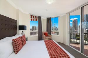 a hotel room with two beds and a balcony at Marrakesh Apartments in Gold Coast