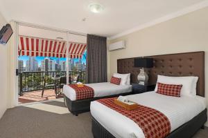 a hotel room with two beds and two lamps at Marrakesh Apartments in Gold Coast