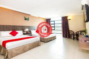 una habitación de hotel con 2 camas y un cartel en la pared en Crystal City Hotel, en Kuantan