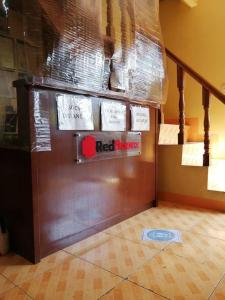 a red broker sign on a wall next to a staircase at RedDoorz near SM Batangas City in Batangas City