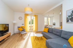 un soggiorno con divano blu e cuscini gialli di Scandinavian Gdynia a Gdynia
