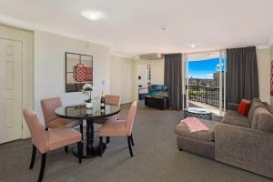 a living room with a table and a couch at Marrakesh Apartments in Gold Coast