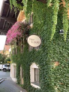 un bâtiment recouvert de lierre et muni d'un panneau. dans l'établissement Haus Lukas, à Hopfgarten im Brixental