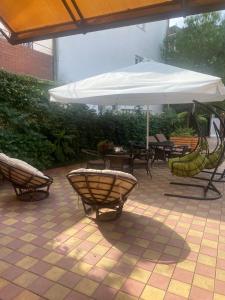 阿德列爾的住宿－塔拉索旅館，一个带桌椅和遮阳伞的庭院