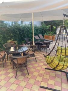 阿德列爾的住宿－塔拉索旅館，一个带桌椅和遮阳伞的庭院