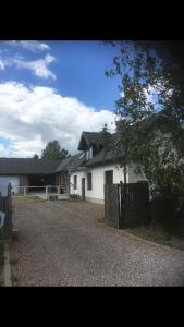 ein weißes Haus mit einem Zaun davor in der Unterkunft Agroturystyka Pokoje Stajnia Lidia in Serock